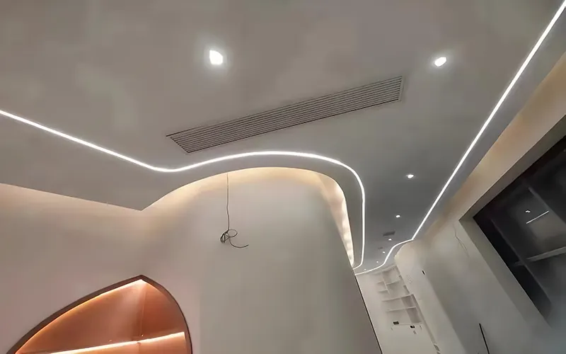 Bande LED installée dans un canal flexible incurvé en aluminium dans le cadre d'un projet d'éclairage de plafond